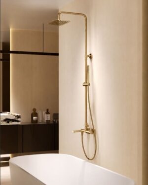 Coluna de banheira monocomando Toscana em ouro escovado instalada em casa de banho elegante.